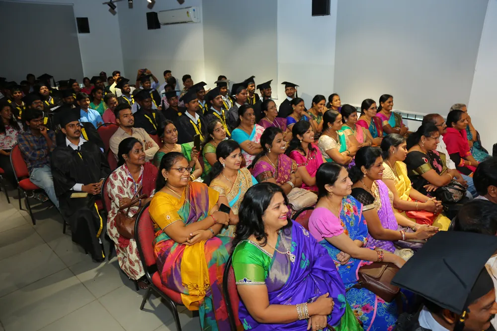 Families and graduating NIFS students in caps and gowns at a NIFS graduation ceremony