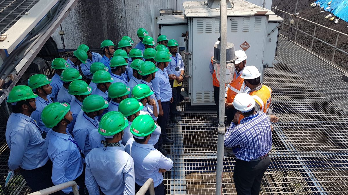 NIFS fire and safety students in safety helmets on an industrial site visit with plant safety officers